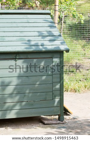 A large wooden chicken coop or hen house painted green for flocks of birds to roost in