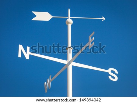 White Weathervane Against a Radiant Blue Sky Royalty-Free Stock Photo #149894042