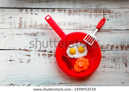 Play toy food and pan on the wooden table background