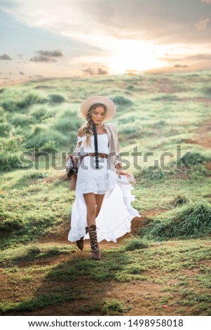 Young beautiful woman in hat and long white dress on nature. boho, hipster, fashion concept 