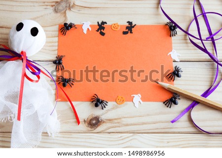 Halloween background. Halloween flatlay. Ghost, bat, pumpkin and spiders on a wooden background with place for text.