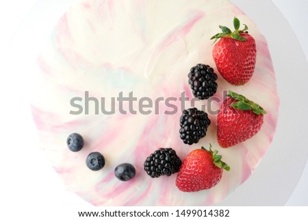 Birthday cake with strawberries, blueberries and blackberry on white background. Picture for a menu or a confectionery catalog.