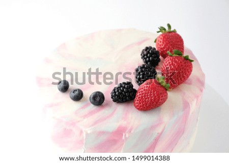 Birthday cake with strawberries, blueberries and blackberry on white background. Picture for a menu or a confectionery catalog.