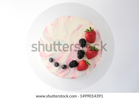 Birthday cake with strawberries, blueberries and blackberry on white background. Picture for a menu or a confectionery catalog. Top view.