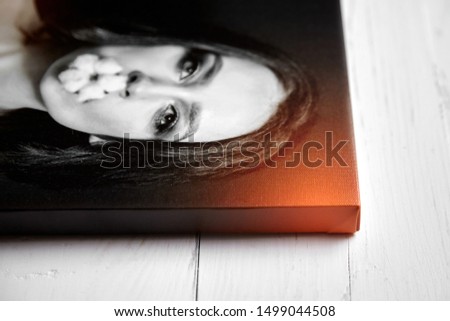 Photo canvas print on glossy synthetic canvas and stretched on wooden stretcher bar with gallery wrap, lateral side closeup. Selective focus