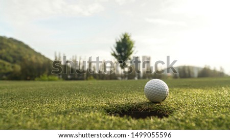 golf ball on lip of the cup 