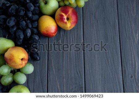 Background for an inscription with fruits. Apple, grape, nectarine on a gray wooden background. Fresh Vitamins in Food