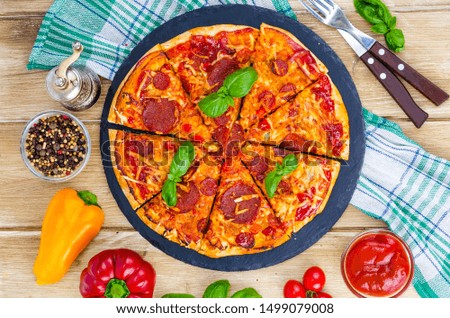 Pizza with salami, cheese and fresh vegetables. Studio Photo