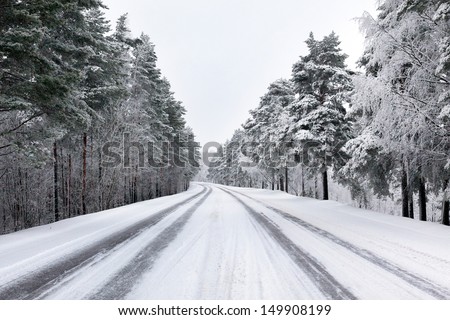 Snowy street through forest Royalty-Free Stock Photo #149908199