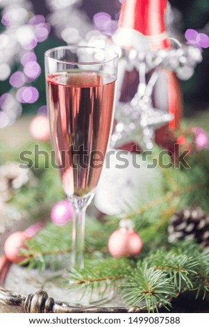 Pink champagne in a glass and christmas decorations