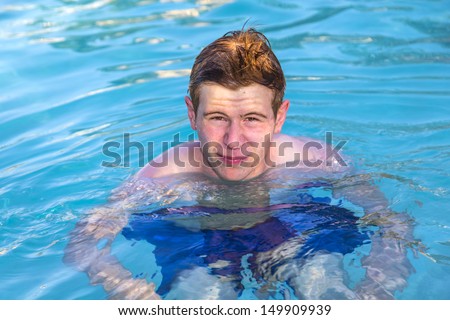 teen boy enjoys swimming in the pool