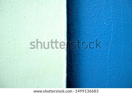 Two tones of blue color bands on a freshly painted wall in hard light, centered with two equal parts.