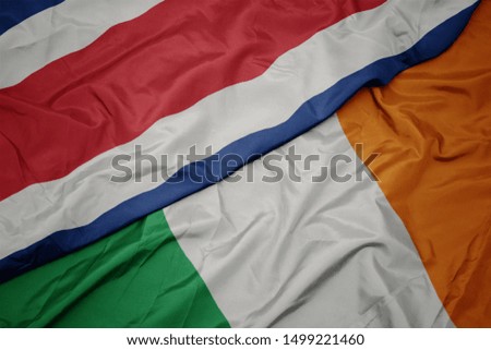 waving colorful flag of ireland and national flag of costa rica. macro