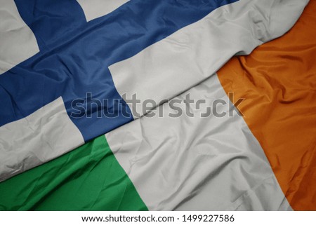 waving colorful flag of ireland and national flag of finland. macro