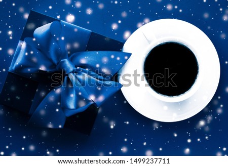Hot drink, luxury festive menu and Valentines Day card concept - Winter holiday gift box, coffee cup and glowing snow on blue flatlay background, Christmas time present surprise