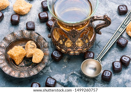 Eastern tea concept.Eastern tea in traditional glass with chocolate candy