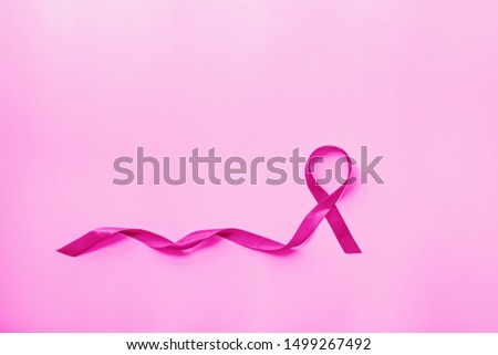 Sweet pink ribbon shape on pink background for Breast Cancer Awareness symbol to promote in october month campaign. Flat lay with copy space, top view, mockup, overhead, template. Health care concept