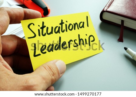 Man holds sign Situational Leadership on a yellow piece of paper. Royalty-Free Stock Photo #1499270177