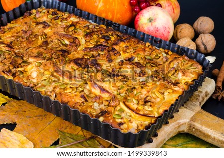 Homemade apple pie with nuts and pumpkin seeds. Studio Photo