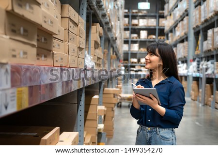 Young asian woman auditor or trainee staff work looking up and checks the number of items store by digital tablet. Asian owner or small business concept. Royalty-Free Stock Photo #1499354270