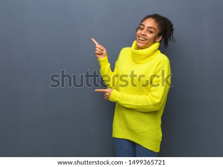 Young black woman pointing to the side with finger