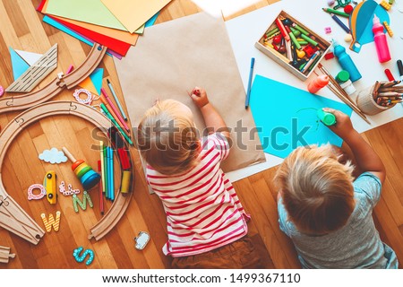 Kids draw and make crafts. Children with educational toys and school supplies for creativity. Background for preschool and kindergarten or art classes. Boy and girl play at home or daycare Royalty-Free Stock Photo #1499367110