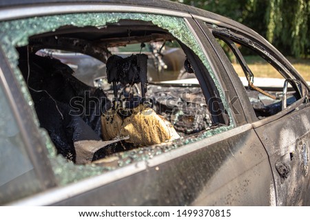 Car after the fire. Burned out car with an open hood. Arson, burnt car. Burnt interior trim, steering wheel, dashboard, Royalty-Free Stock Photo #1499370815