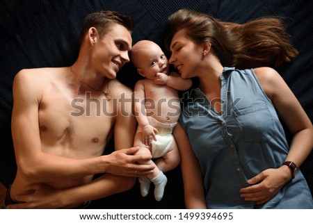 Young parents have fun with their little son