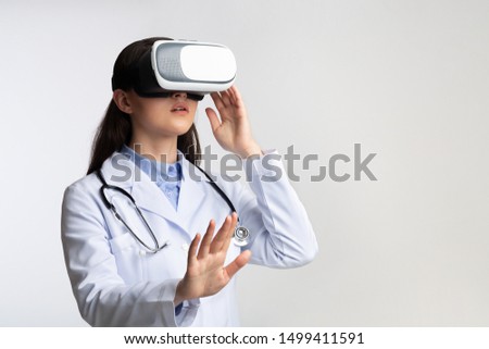 Innovative Medicine. Female Doctor Wearing Virtual Reality Glasses Over White Studio Background. Free Space