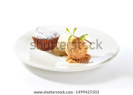 Whole hot chocolate fondant with ice cream ball and condense milk on white plate isolated. Restaurant dessert with fresh brownie, muffin or small chocolate cake with crunchy rind and mellow filling Royalty-Free Stock Photo #1499425502