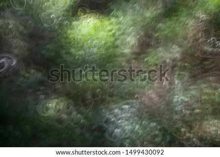 A creative watercolor styled landscape with blurred trees, leaves and grass on a sunny midsummer day