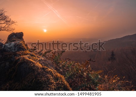 view over taunus, germany.  great view over a valley in the sunset or sunrise.  with a lot of haze and clouds in the picture, which make a great color