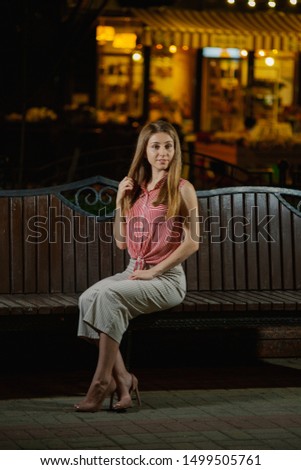 Nice girl on a bench in the evening in the park.