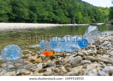 Plastic pollution in water. Dirty plastic bottles in a river. Pollution and recycle eco concept.