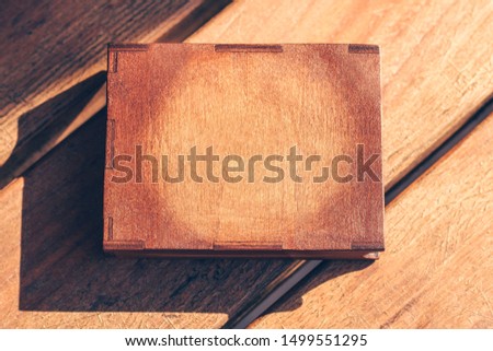 Brown wooden rectangular box on table. Empty clean space for text or frame for photo. Hardwood flat top view. Warm modern natural oak surface background. Retro vintage copy space