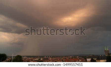 A menacing thunderstorm cell looming over a small european town