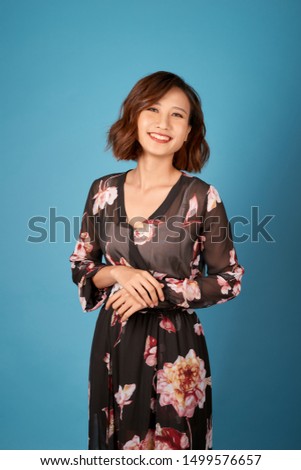 Chilling girl with short hairstyle standing in room on light blue background.