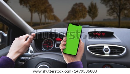 Mock up for smart phone. Watching the phone while driving the car on the long road.
