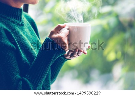 women wearing knitting sweater, drink coffee at home in the living room
