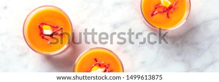 Salmorejo, Spanish cold tomato and bread soup, in glasses on a marble background, shot from the top with copy space, panoramic shot