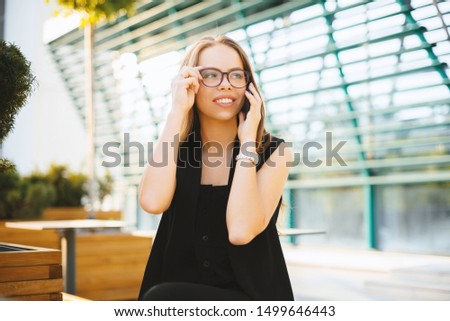 Photo of handsome young lady, talking on phone at terace, and touching glasses