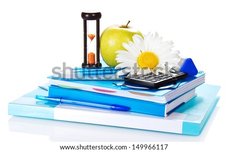 The books, notepad, stationery, calculator, hourglass, apple and chamomile isolated on white