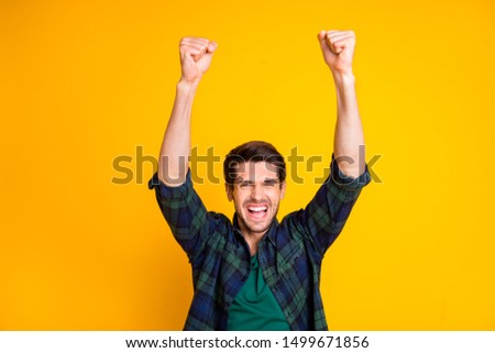 Photo of cool guy watching football game raising fists supporting favorite team wear casual plaid shirt isolated yellow color background