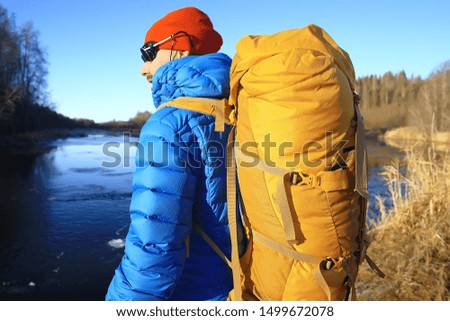back view of  tourist with  backpack hiking in winter in Norway / one man carrying  backpack in a Norwegian winter landscape.