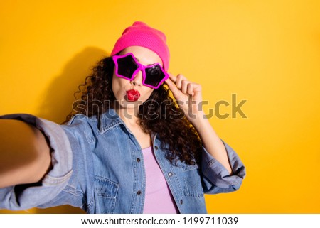 Photo of funny lady at disco party making selfies sending air kisses wear casual trendy clothes and cool star specs isolated yellow color background