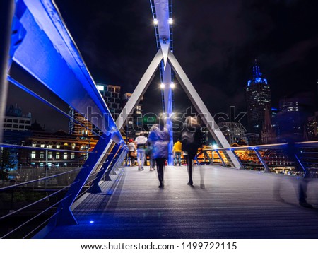 Unrecognisable people crossing the bridge over the Yarra river in Melbourne in winter. Royalty-Free Stock Photo #1499722115