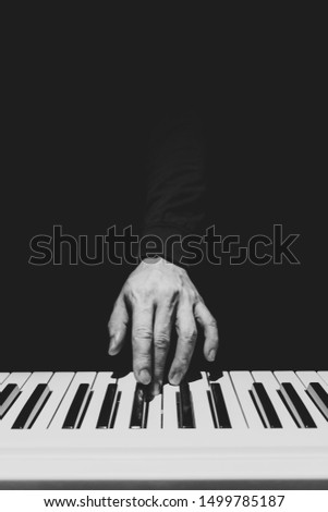 BW male musician hand playing on piano keys. music background