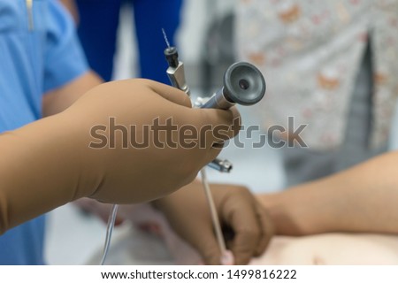 A team of urologist doctors performing a cystoscopy using a cystoscope. In a sterile operating room. close-up Royalty-Free Stock Photo #1499816222
