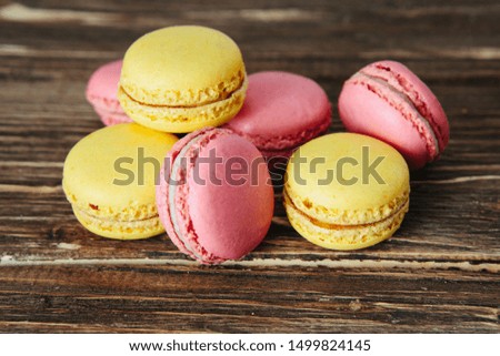 Sweet colorful French macaroon cookies dessert on brown wooden table