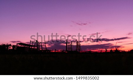 Wiltshire red, orange, pink, violet sunset, with farm machinery on the horizon